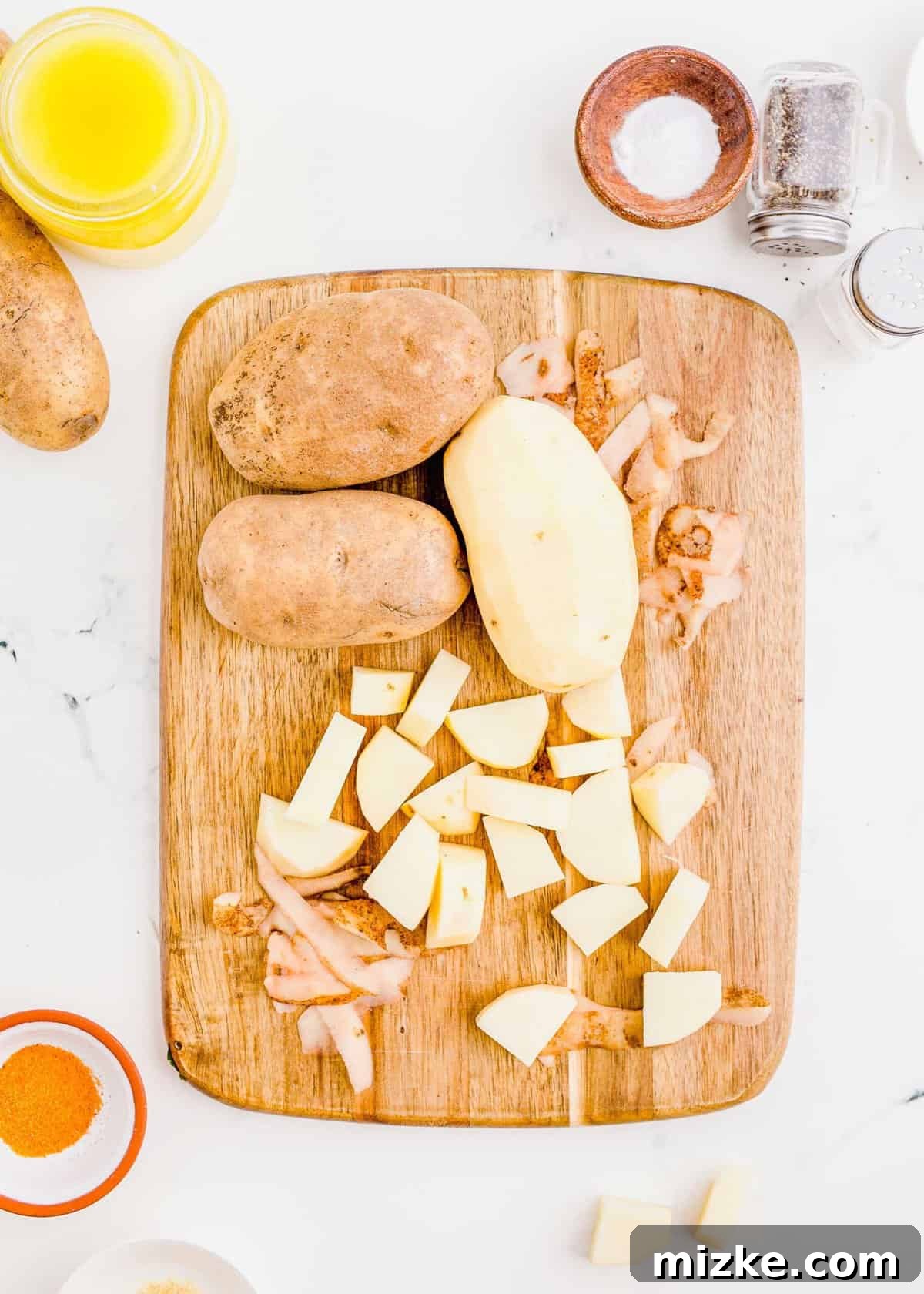 Shatteringly Crisp Duck Fat Potatoes 5 Image of russet potatoes on a cutting board, being precisely cut into uniform cubes