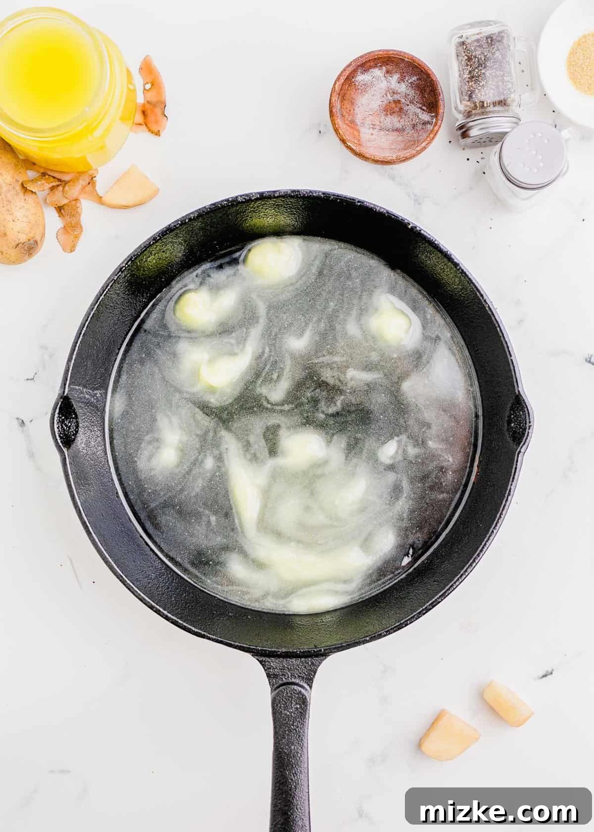 Shatteringly Crisp Duck Fat Potatoes 7 Overhead shot of rich duck fat melting and shimmering in a deep cast iron skillet