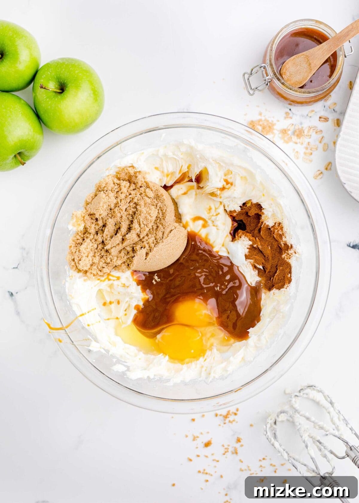 Unmixed cheesecake filling ingredients: cream cheese, Greek yogurt, egg, brown sugar, caramel, cinnamon, vanilla. A vibrant bowl showcasing the unmixed components of the cheesecake filling: softened cream cheese, rich Greek yogurt, a single egg, golden brown sugar, luscious caramel sauce, aromatic cinnamon, and fragrant vanilla extract, awaiting their transformation into a smooth blend.