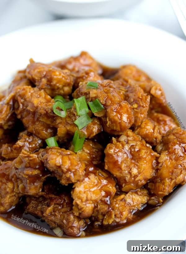 Homemade General Tso Chicken with a Healthy Twist Close-up of Lightened Up General Tso Chicken with sauce, ready to be served.