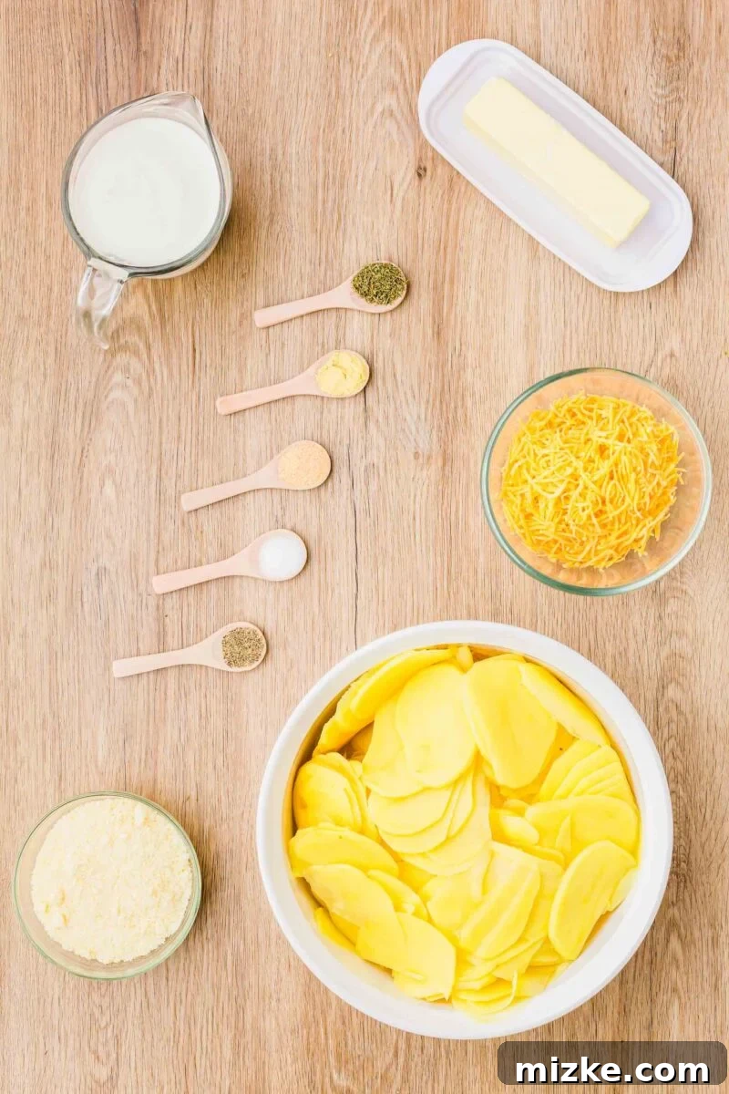 Simply Irresistible Creamy Potato Gratin 5 An overhead view of the key ingredients for making potatoes au gratin: a stick of butter, shredded cheddar cheese, thinly sliced yellow potatoes, grated parmesan cheese, various spices, and a container of heavy cream.