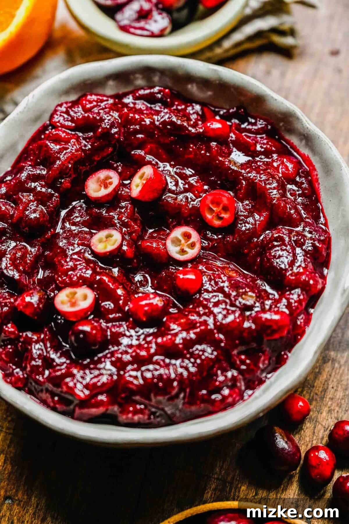 This cranberry cherry compote recipe is tart and sweet, takes only 25 minutes to make, and can be made in advance for any Thanksgiving meal. Close up of a bowl of cranberry cherry compote topped with slices of fresh cranberry