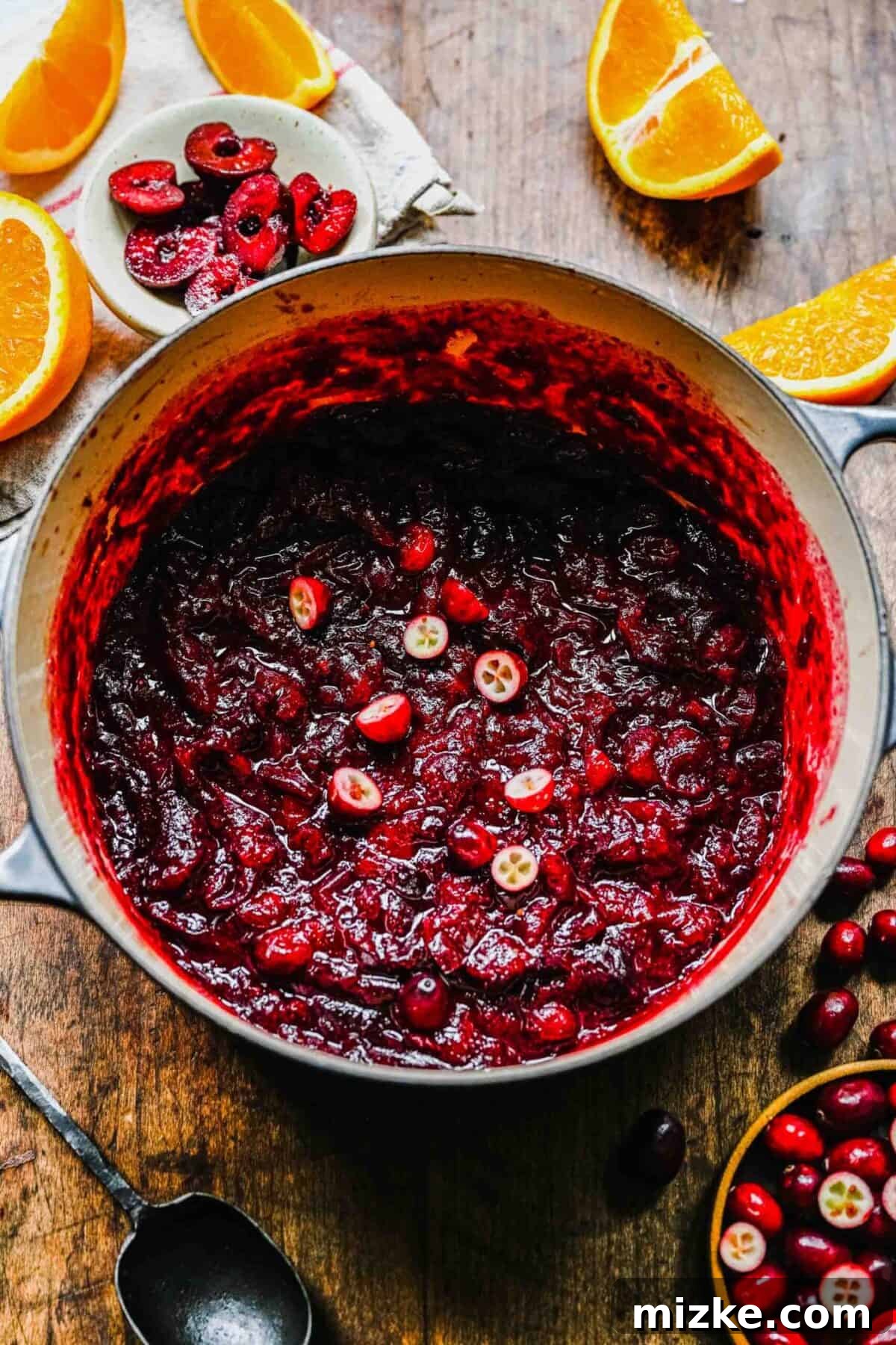 This cranberry cherry compote recipe is tart and sweet, takes only 25 minutes to make, and can be made in advance for any Thanksgiving meal. A pot filled with cranberry cherry compote, topped with fresh cranberries
