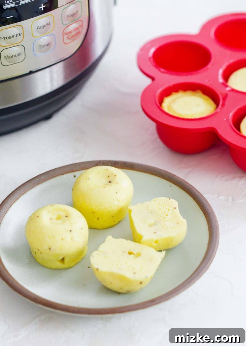 Fluffy Instant Pot Egg Bites 13 Instant Pot egg bites sliced in half on a ceramic plate, beautifully arranged in front of an Instant Pot and red egg molds, showcasing their perfect texture.