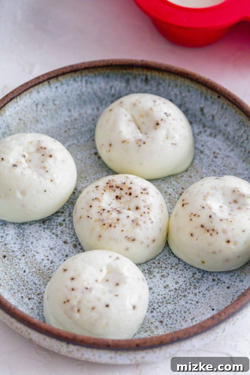 Fluffy Instant Pot Egg White Bites 2 Close-up image of fluffy Instant Pot egg white egg bites with ground pepper on top, served on a speckled blue plate.