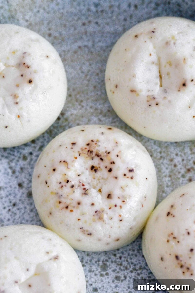 Fluffy Instant Pot Egg White Bites 3 Detailed close-up of a single egg white egg bite topped with black pepper, showcasing its light and airy texture.