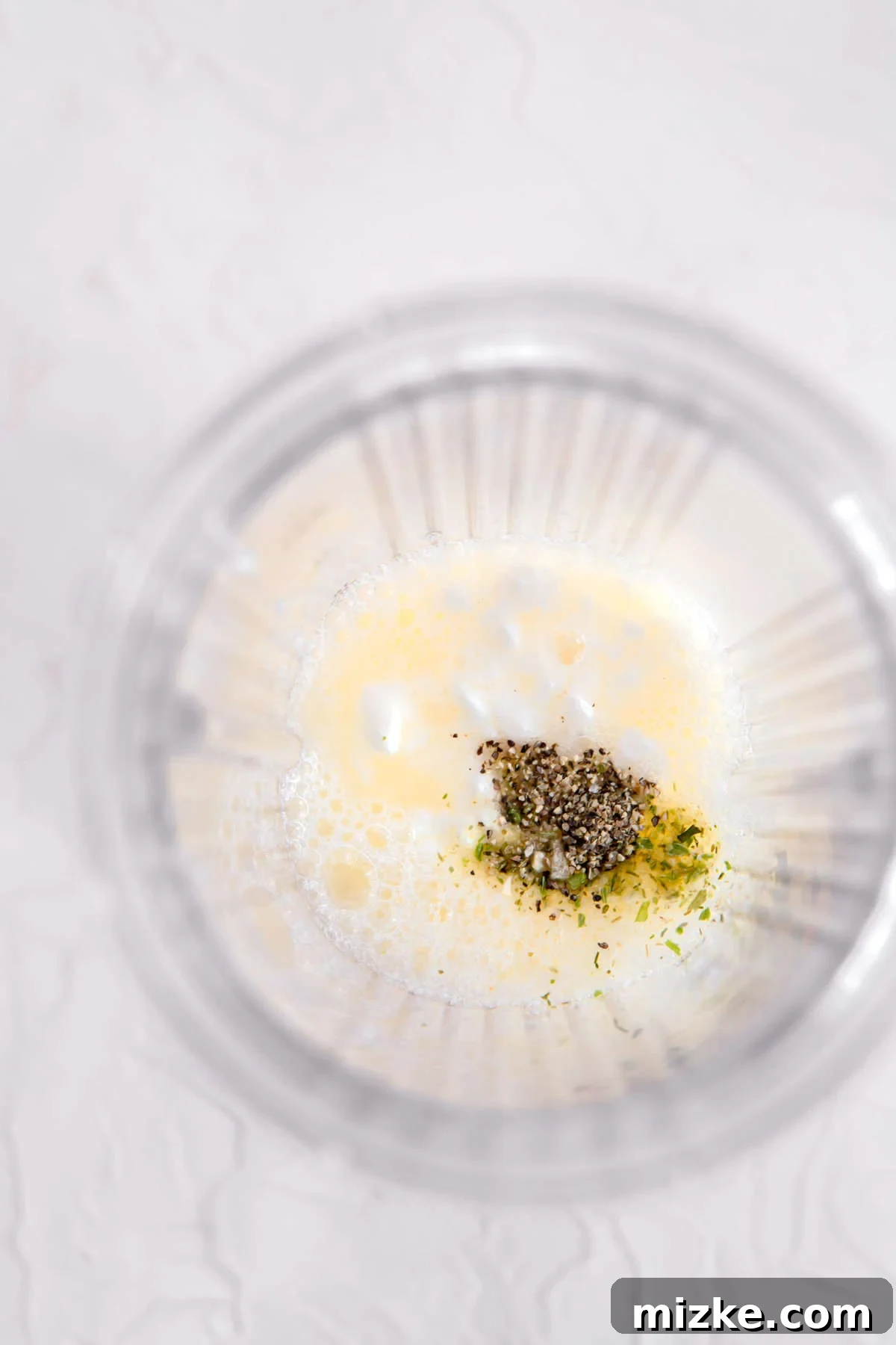 Fluffy Instant Pot Egg White Bites 6 Egg whites, cottage cheese, and various seasonings added into a blender jar, prepared for mixing.