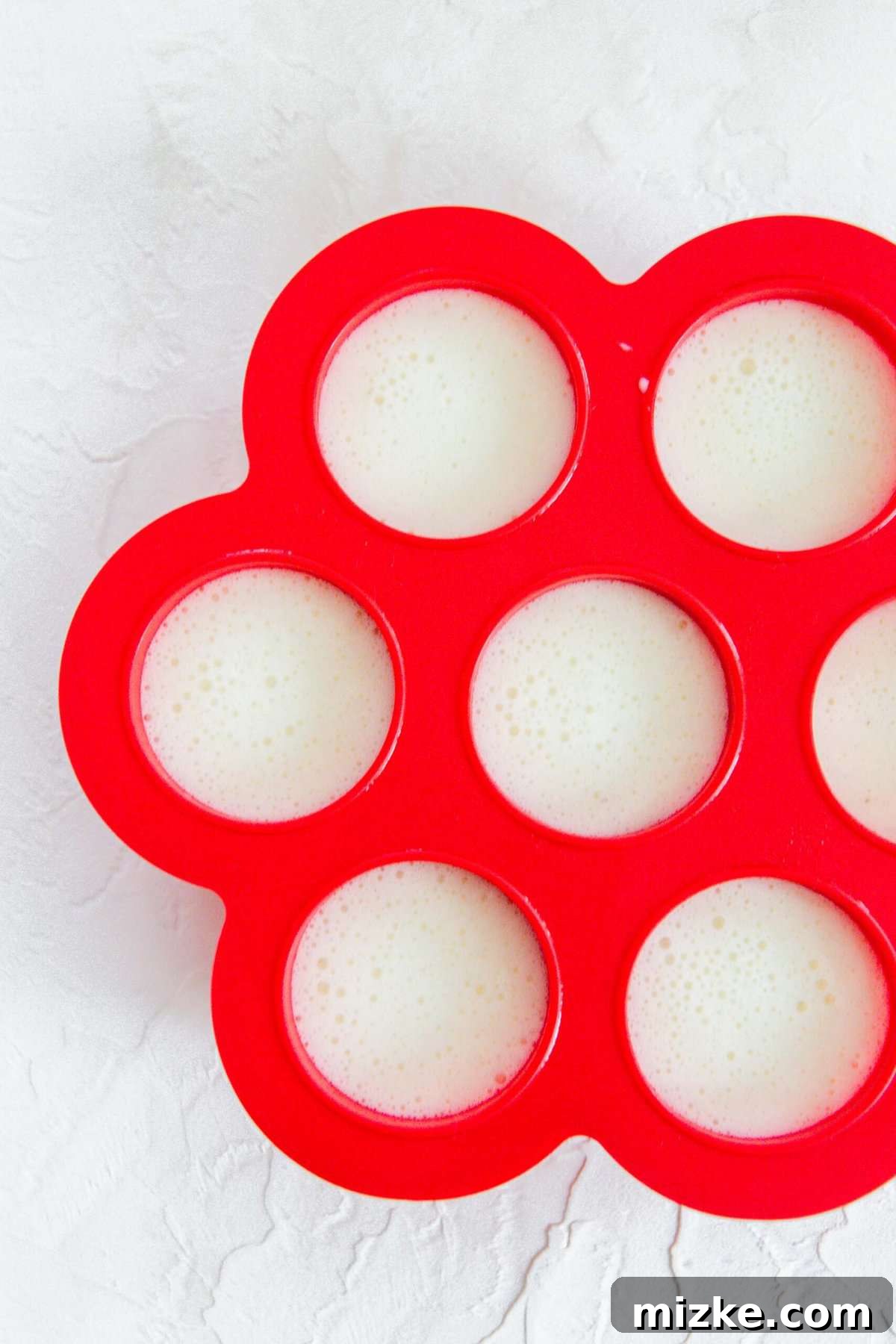 Fluffy Instant Pot Egg White Bites 8 Red silicone egg mold completely filled with the egg white mixture, ready for cooking.
