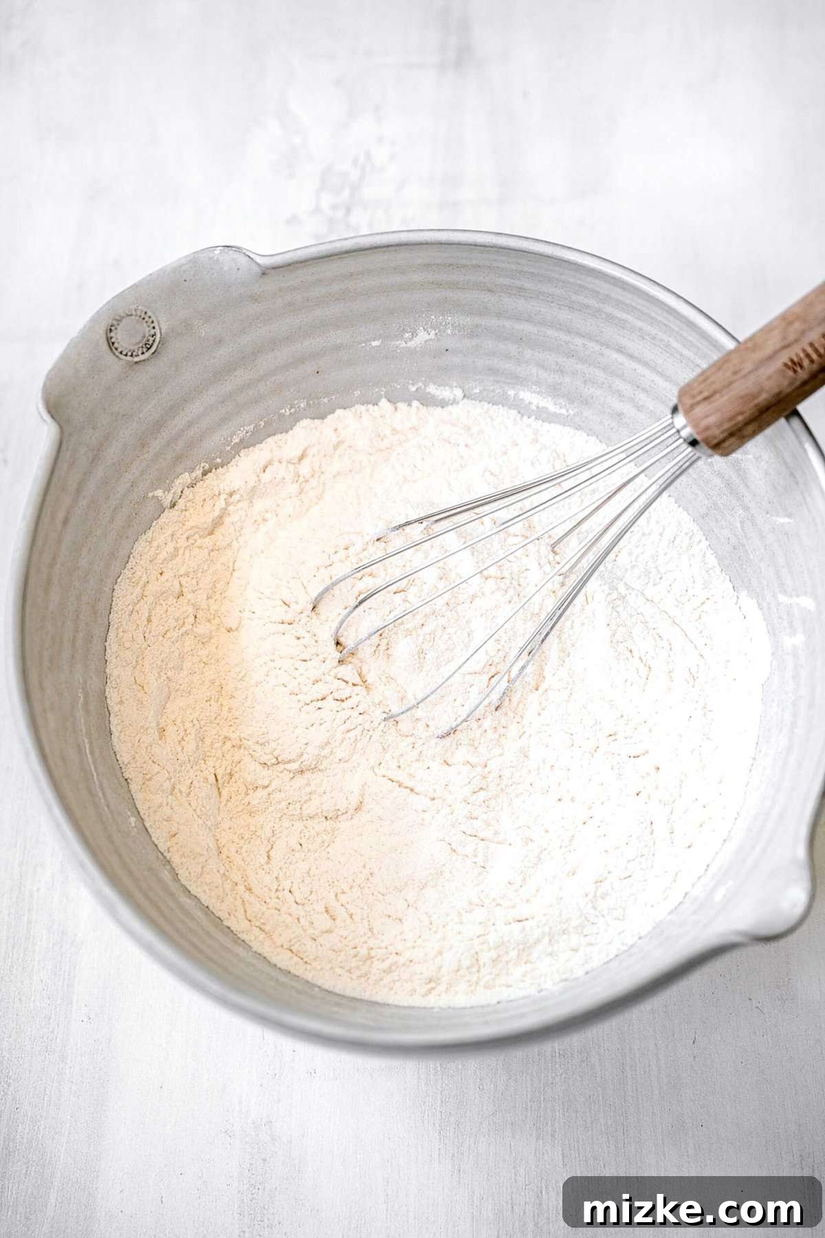 White Chocolate Peppermint Bliss Cookies 4 whisking the dry ingredients together in a large grey bowl with a spout