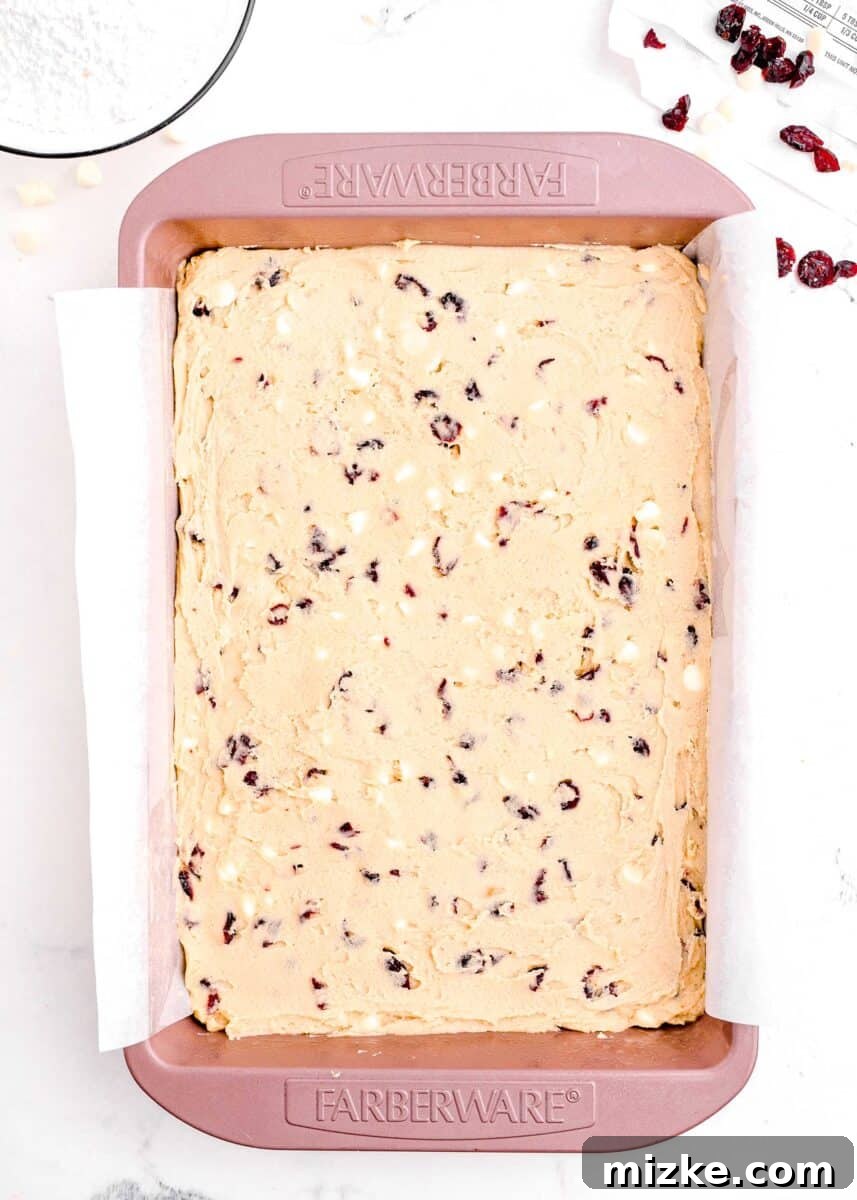 Bake Your Own Cranberry Bliss 12 Cranberry bliss bar dough spread evenly in a large pink baking sheet lined with parchment paper.