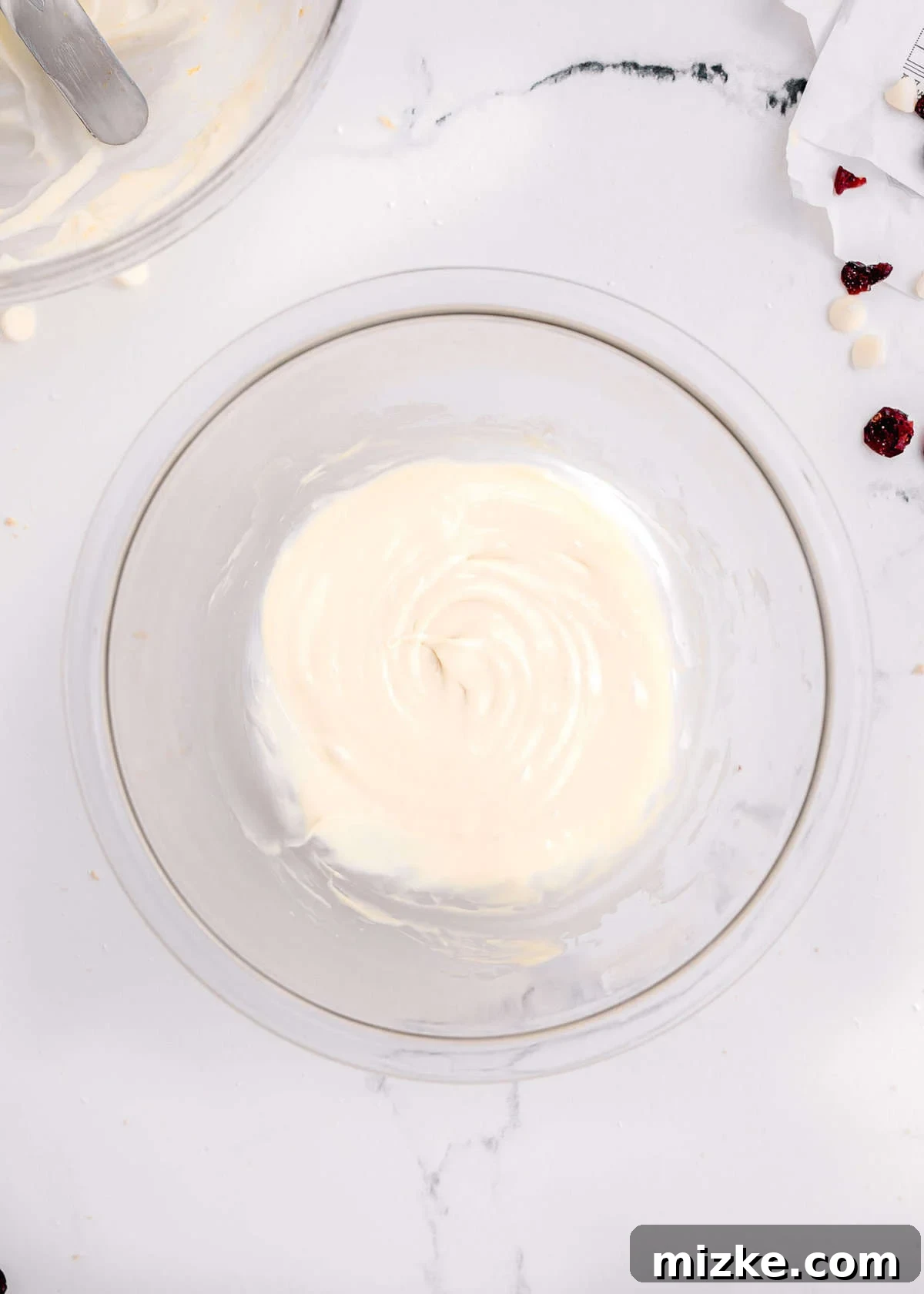 Bake Your Own Cranberry Bliss 17 Smooth, melted white chocolate in a clear glass bowl, prepared for drizzling.