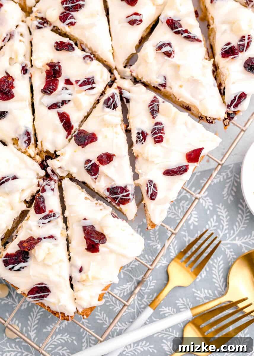 Bake Your Own Cranberry Bliss 19 Several cranberry bliss bars cut into triangles, neatly arranged on a metal baking rack, ready to be served or stored.