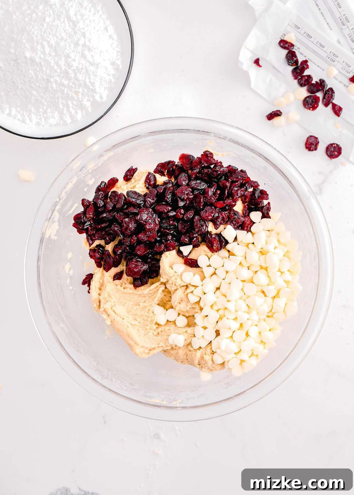 Bake Your Own Cranberry Bliss 10 Folding white chocolate chips and dried cranberries into the blondie dough mixture in a clear glass bowl.