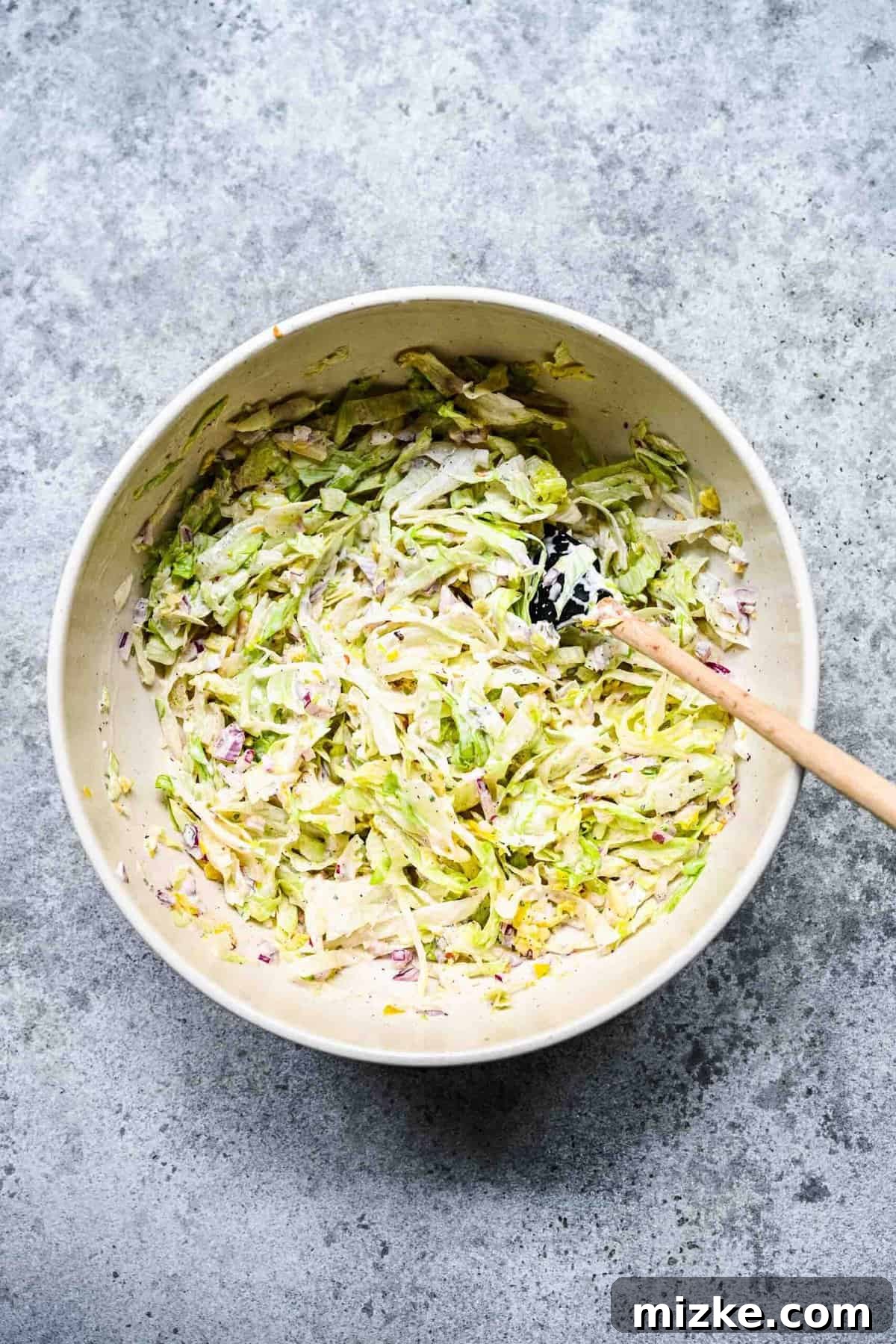 The vibrant and refreshing grinder salad, tossed and ready. A mixing bowl containing the prepared iceberg lettuce-based grinder sandwich salad, perfectly mixed and ready for assembly.