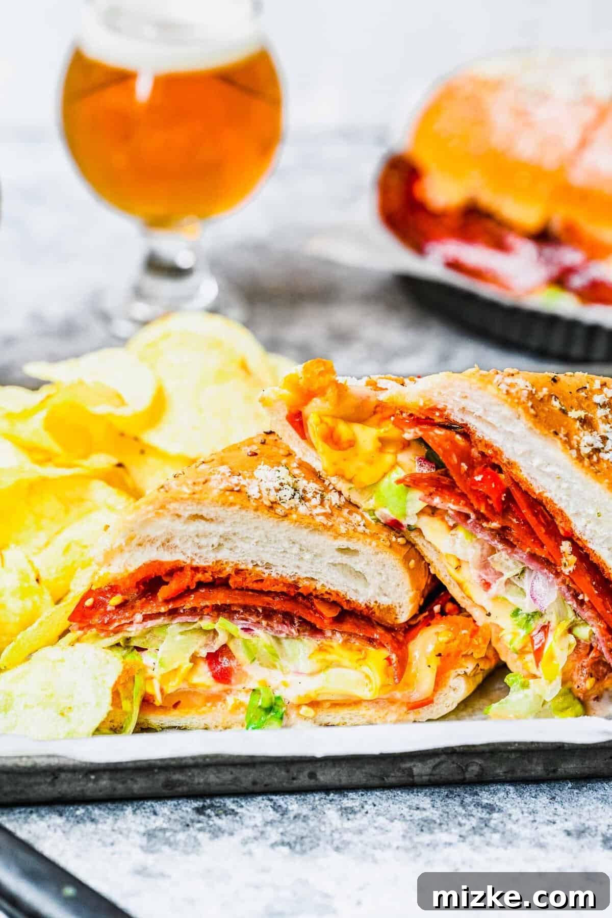 Detailed close-up of a perfectly constructed grinder sandwich. A close-up view of a grinder sandwich cut in half, showcasing the vibrant layers of meat, melted cheese, and fresh salad.