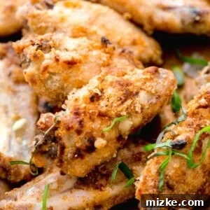 Close-up shot of a Chinese salt and pepper chicken flat wing showing crispy crust. Fresh basil and scallions are sprinkled on top.
