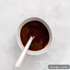 sauce mixed in a white bowl with a metal whisk