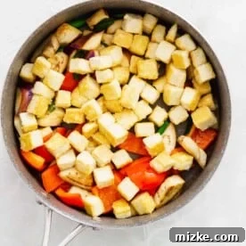 crisped tofu added to the skillet with the eggplant, red bell pepper, and scallions