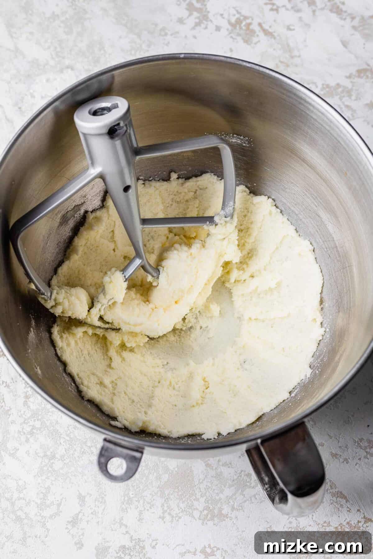 These chocolate peppermint lofthouse cookies are moist, decadent, and bursting with flavor, making them the perfect Christmas cookie. A stand mixer bowl filled with butter and cream that have been beaten, with a paddle attachment in the bowl