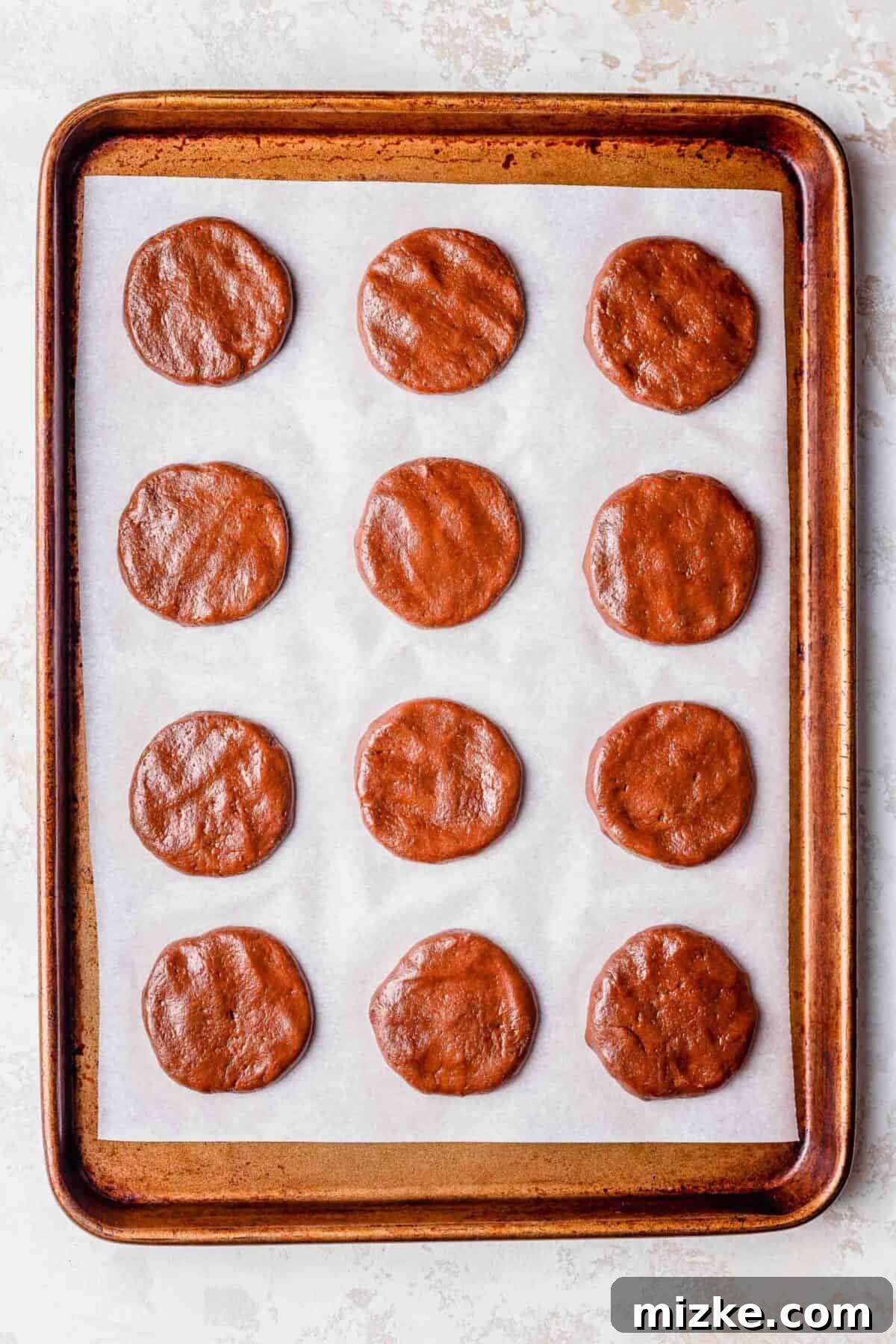 These chocolate peppermint lofthouse cookies are moist, decadent, and bursting with flavor, making them the perfect Christmas cookie. 12 unbaked chocolate peppermint lofthouse cookies on a baking sheet
