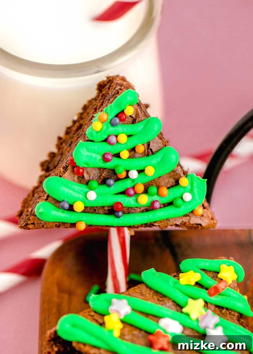 An inviting close-up image of a Christmas tree brownie, showcasing intricate green frosting piping and a generous scattering of vibrant, colorful sprinkles, highlighting its festive appeal.