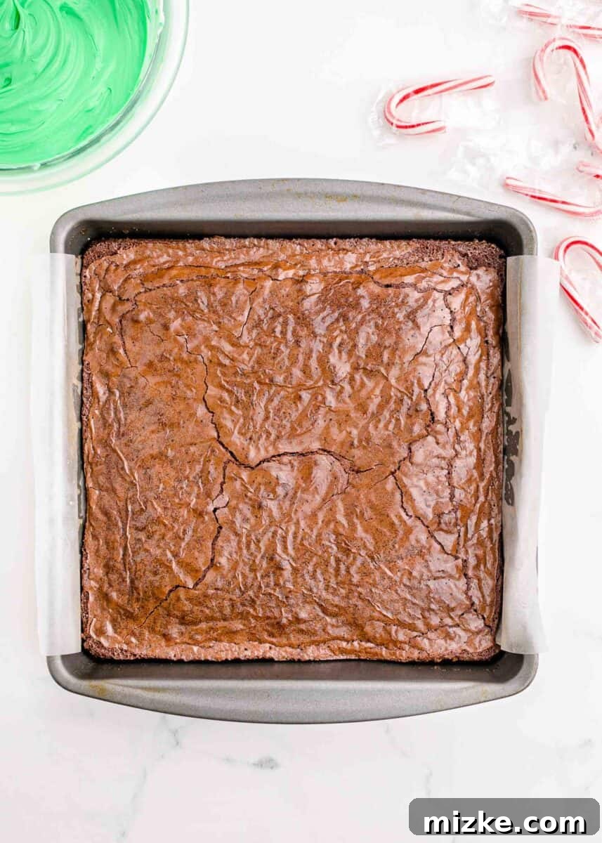 The freshly baked brownie sits golden and perfectly set within the 9x9 inch baking pan, cooling after its time in the oven.