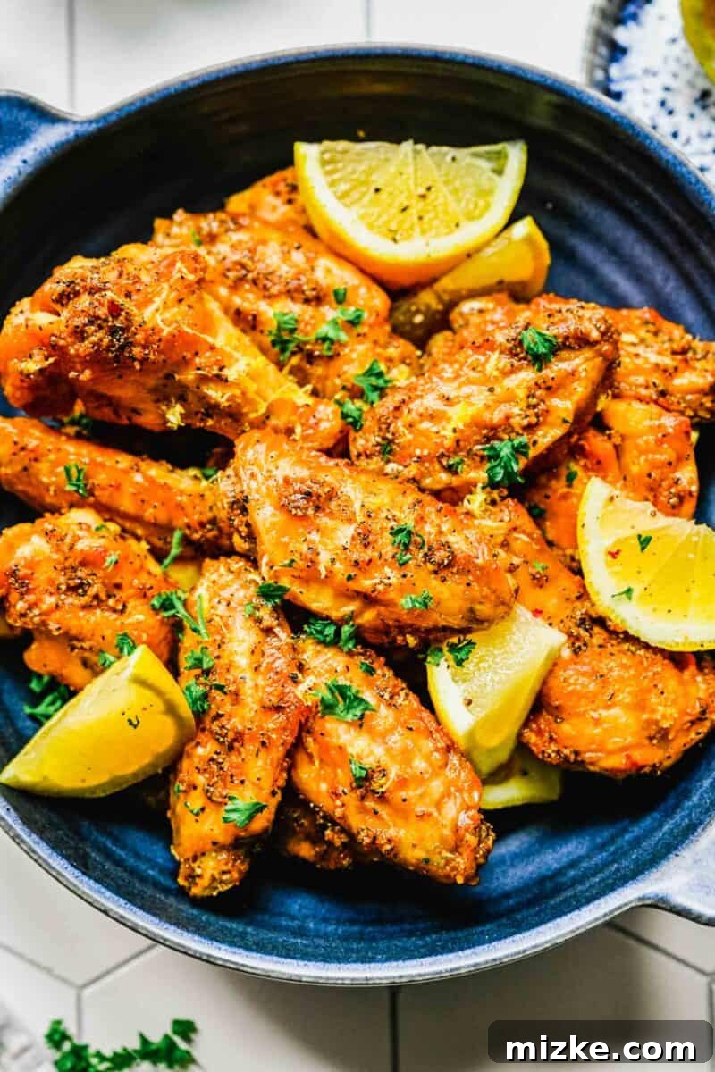 Lemon pepper chicken wings beautifully arranged on a platter with fresh lemon wedges, ready for serving.