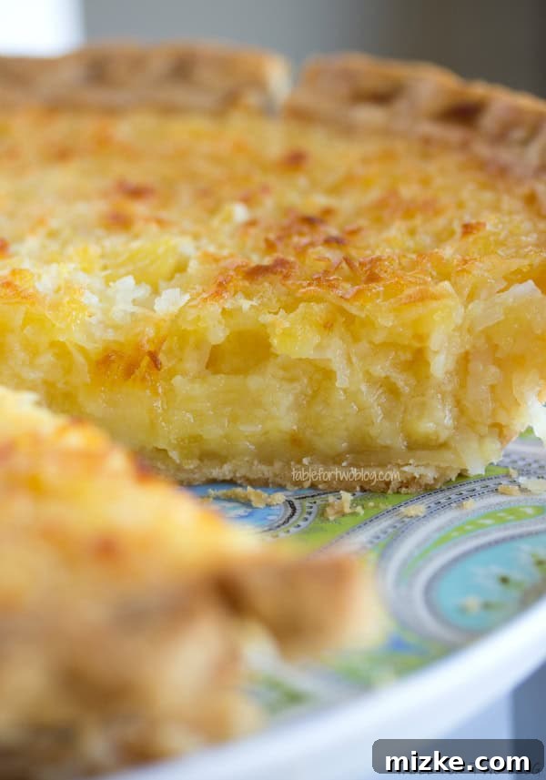 Homemade Coconut Pineapple Pie The full Tropical Pie resting on a cooling rack, highlighting its golden-brown top and the anticipation of its refreshing taste.
