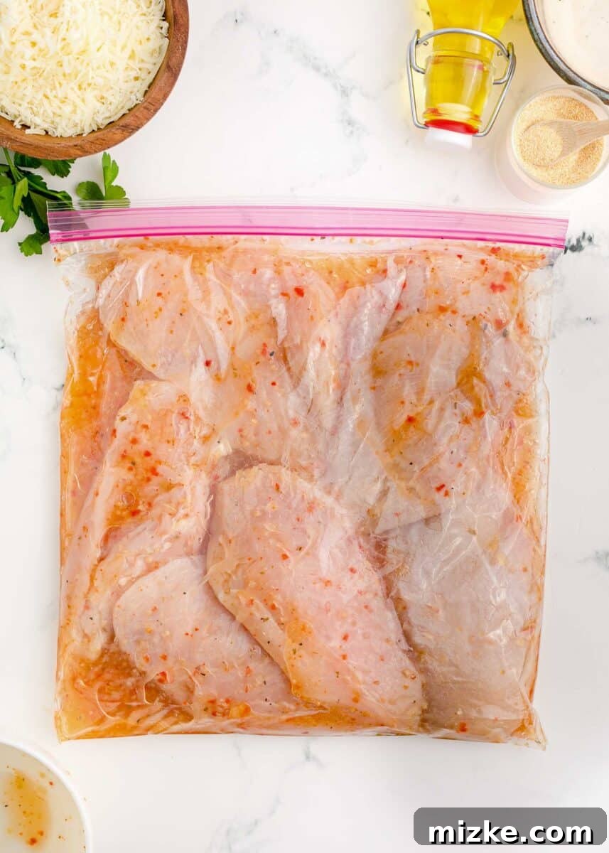Chicken breasts marinating in Italian dressing inside a sealed plastic bag.