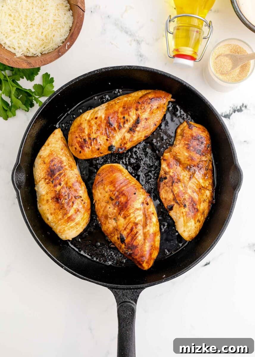 Perfectly browned and seared chicken breasts resting in a cast iron skillet.