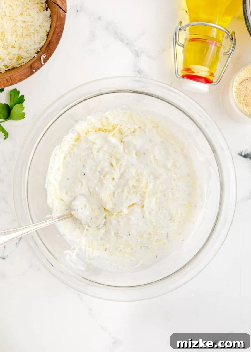The blended Parmesan cheese and ranch dressing mixture in a clear bowl, ready to be spread.