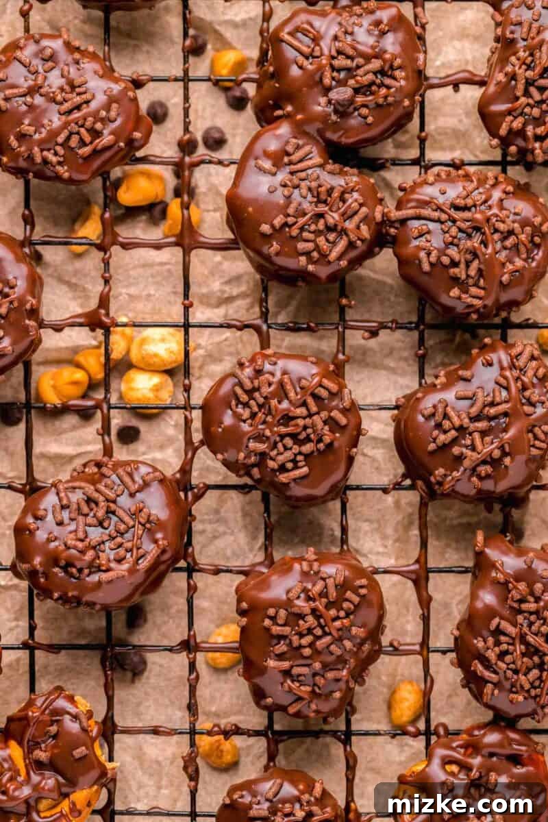 Chocolate covered pretzel bites on a wire baking sheet with chocolate sprinkles on top, showcasing the perfect sweet and salty treat