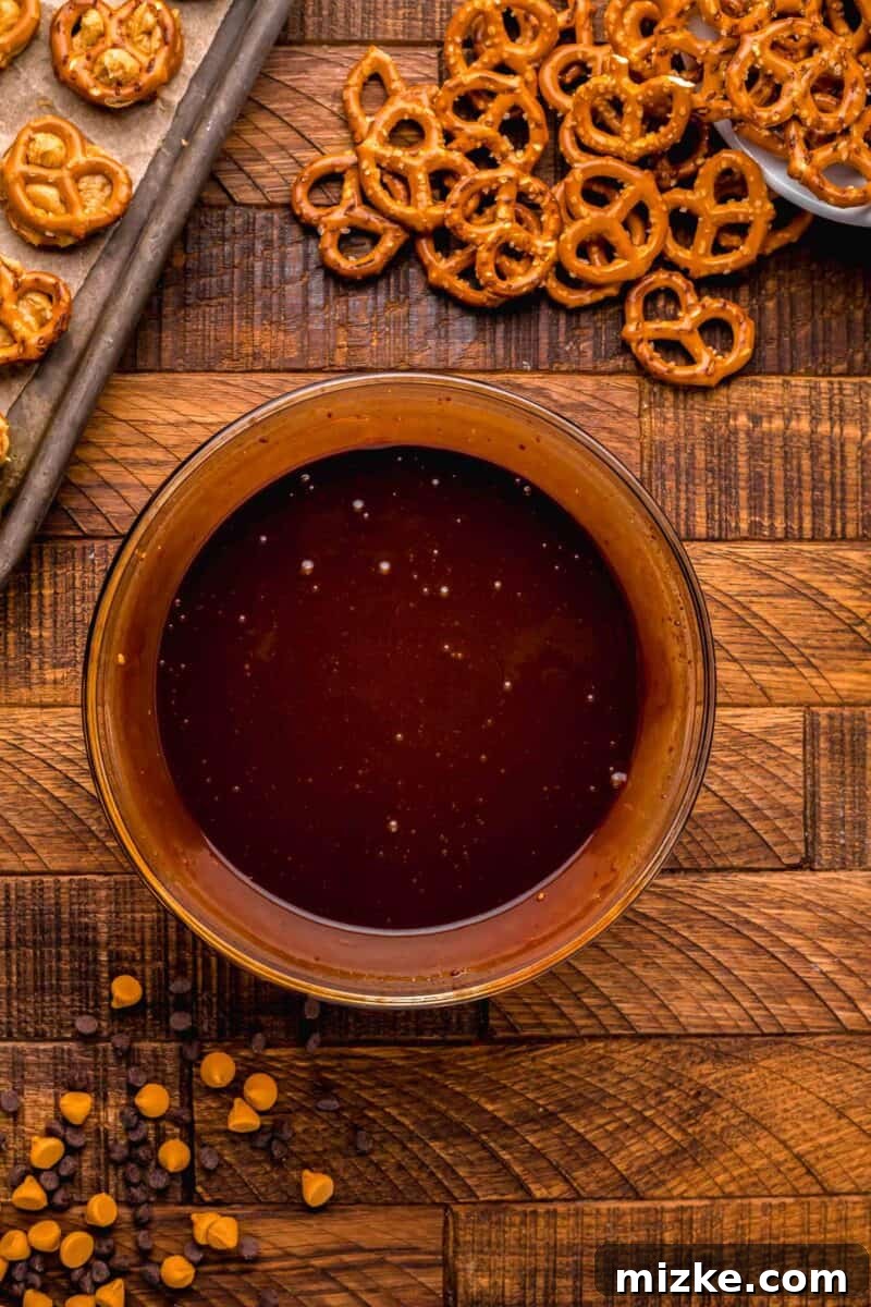 Melted butterscotch and chocolate chip morsels creating a smooth, glossy chocolate dipping sauce in a clear bowl