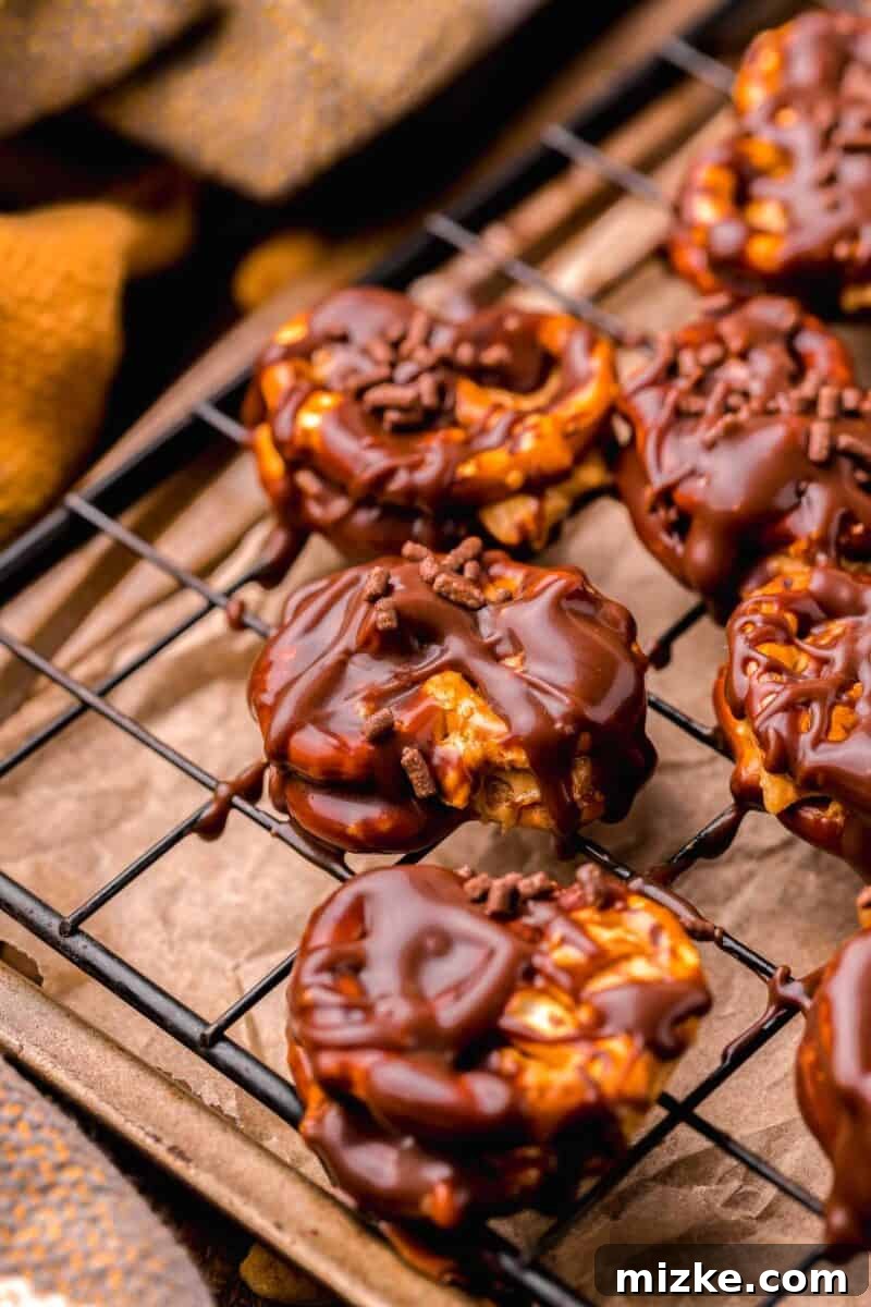 Finished peanut butter pretzel bites with scattered chocolate drizzle on a wire baking sheet, showcasing the delectable final product