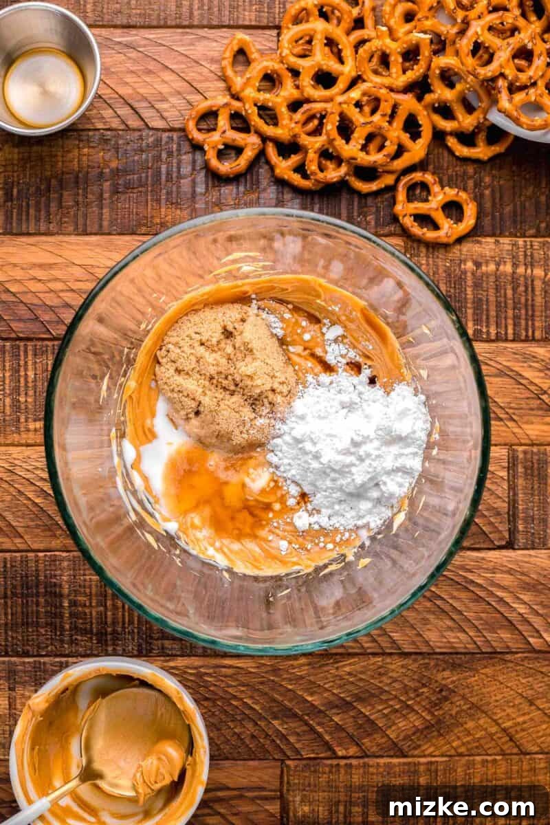 Brown sugar, powdered sugar, heavy cream, and vanilla extract being mixed into the creamy peanut butter mixture