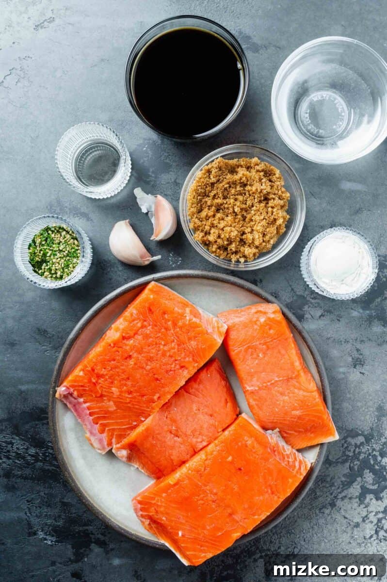 Perfect Air Fryer Teriyaki Salmon 4 Ingredients laid out for Air Fryer Teriyaki Salmon: soy sauce, water, brown sugar, cornstarch, minced garlic, rice vinegar, fresh salmon fillets, and furikake.
