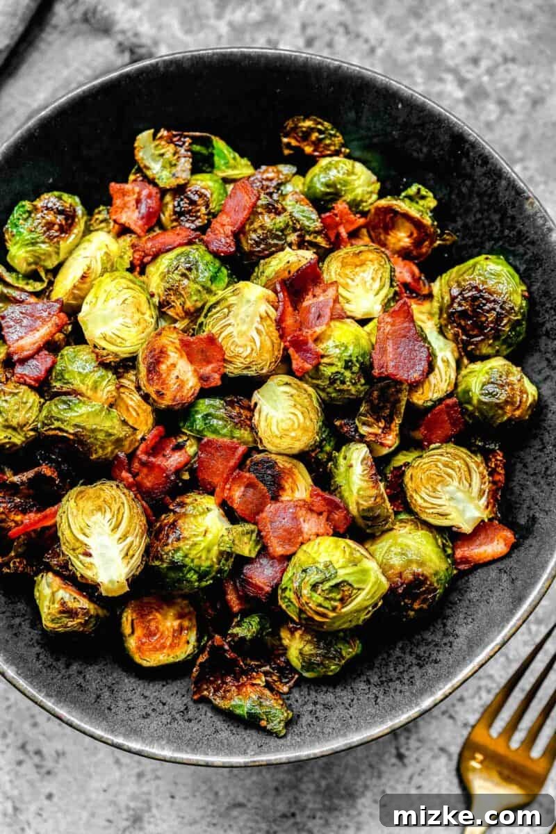 Golden Bacon Roasted Brussels Sprouts 2 Crispy roasted bacon and brussels sprouts in a black ceramic bowl, ready to serve.