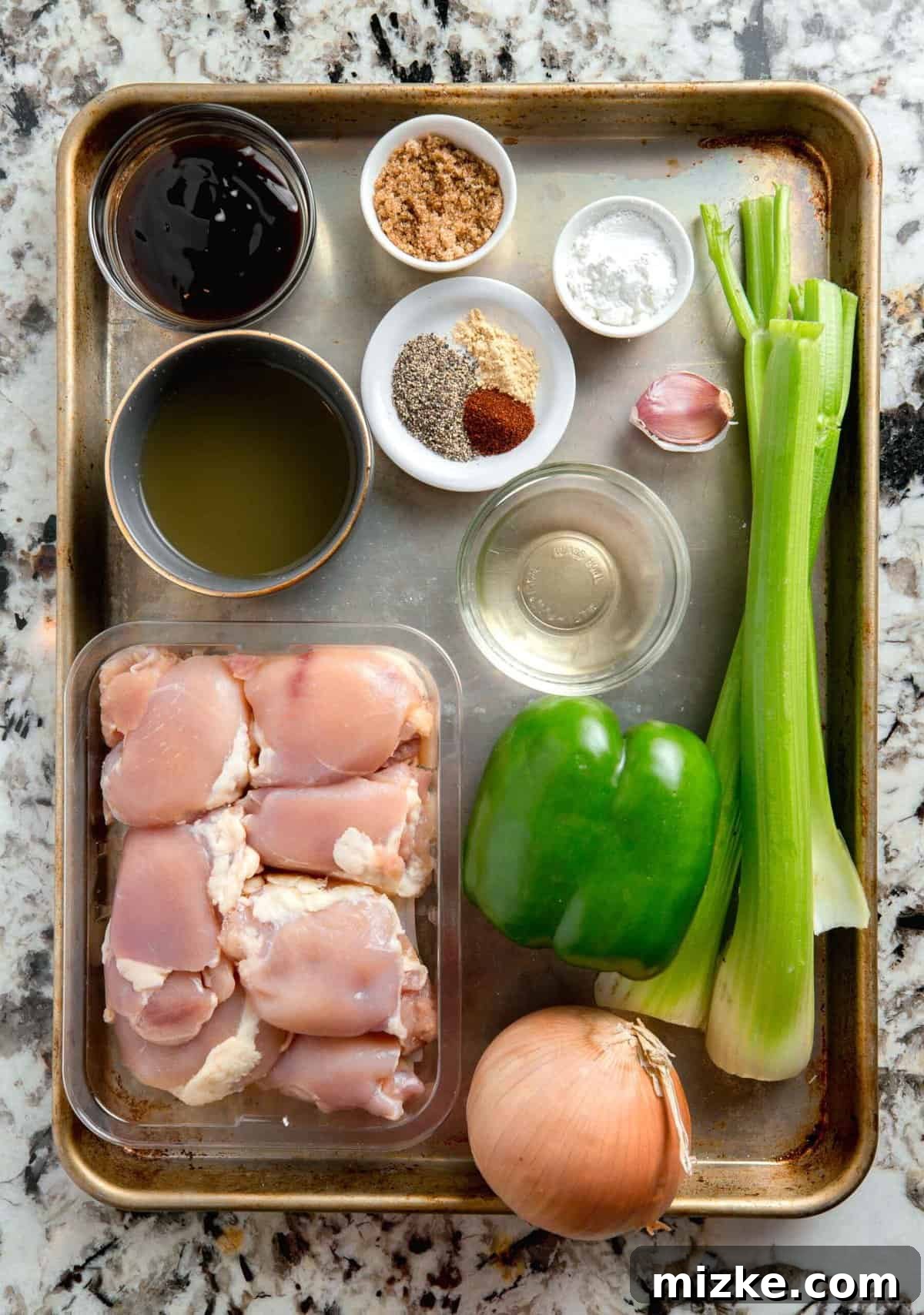 Restaurant-Quality Black Pepper Chicken 4 A colorful array of fresh ingredients laid out, including chicken thighs, green bell peppers, onions, celery, and various sauce components, ready for making black pepper chicken.
