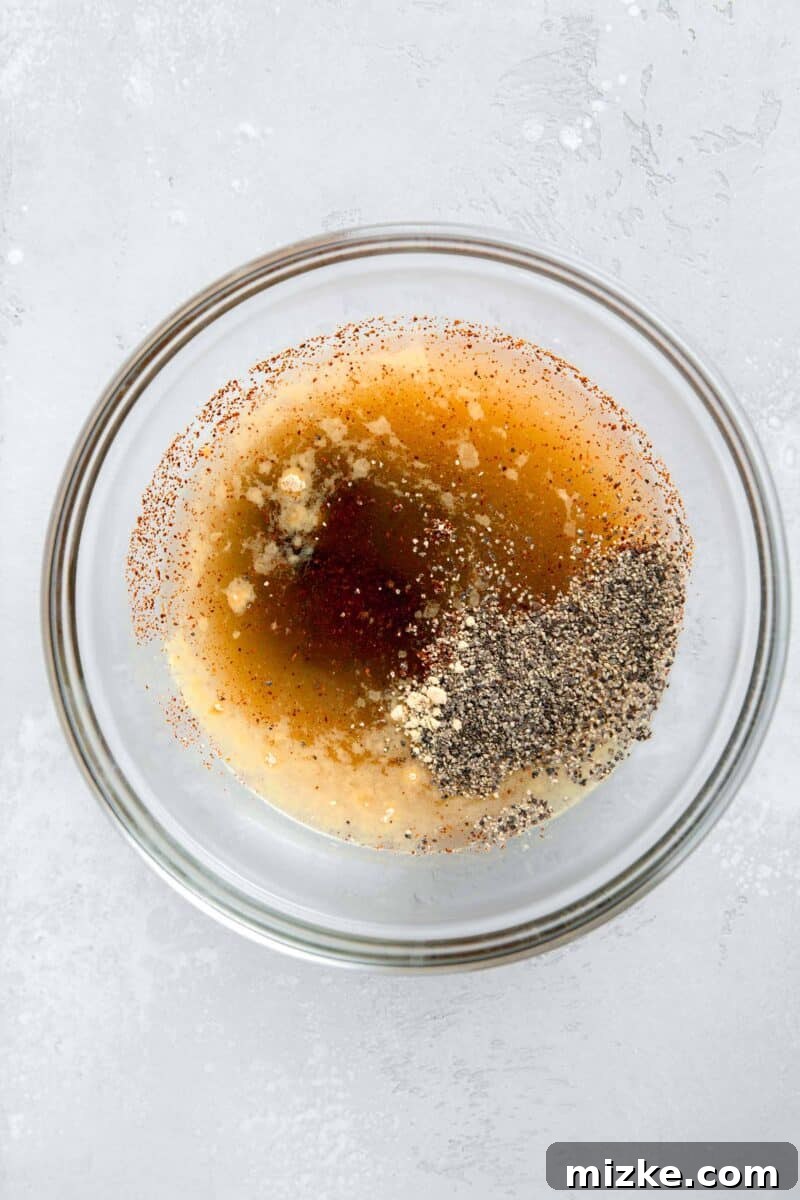Restaurant-Quality Black Pepper Chicken 6 A clear bowl filled with the perfectly whisked black pepper sauce mixture, showcasing its rich color and ready-to-use consistency.