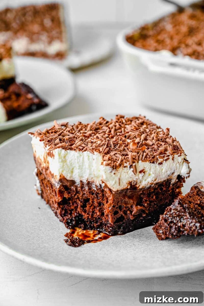 Decadent Chocolate Pudding Poke Cake 9 A pristine piece of chocolate pudding cake, showing the perfect texture after a bite was taken from the corner, revealing the soft cake and creamy pudding.