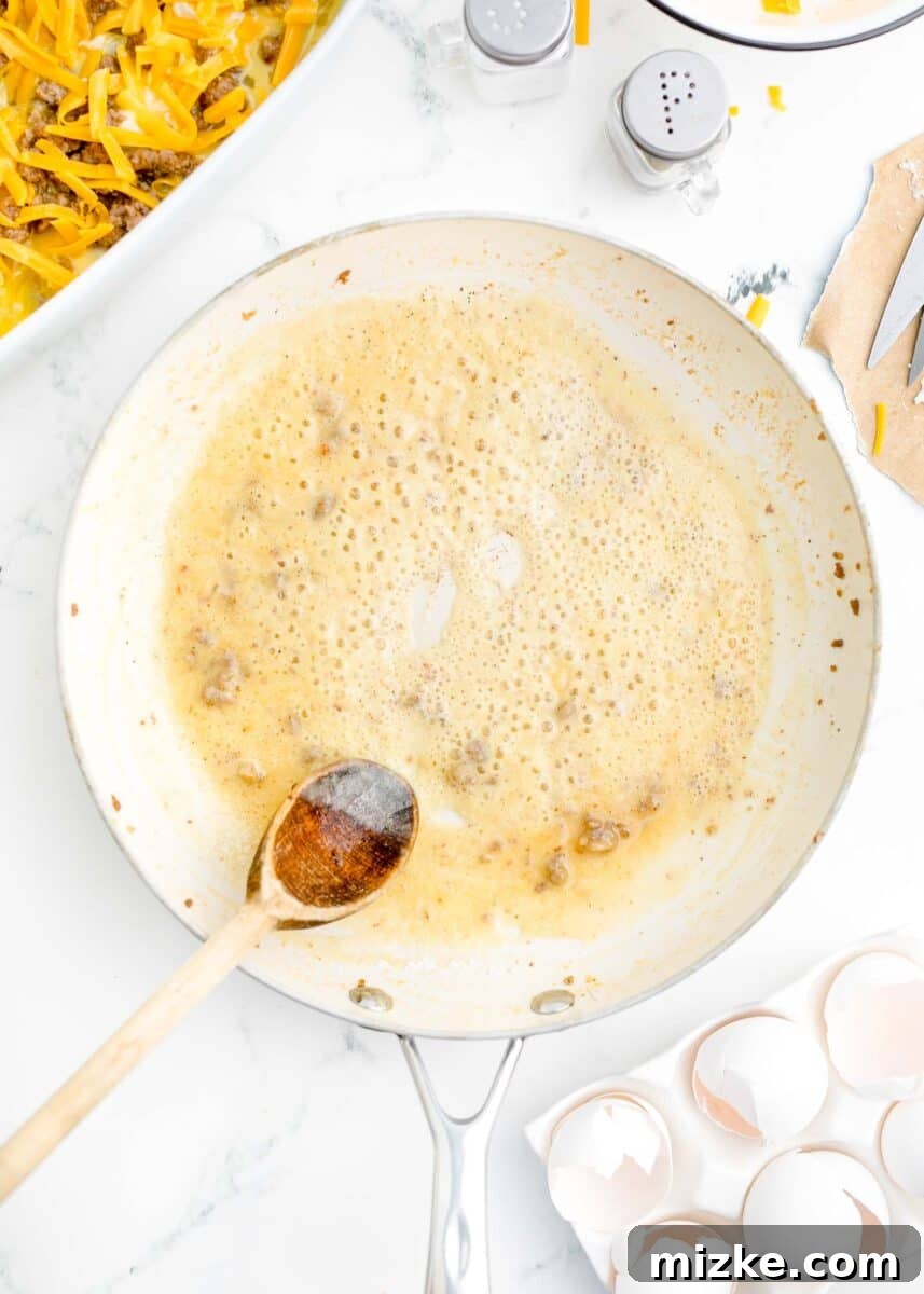 Southern Comfort Biscuit Bake 10 roux being made in a white skillet