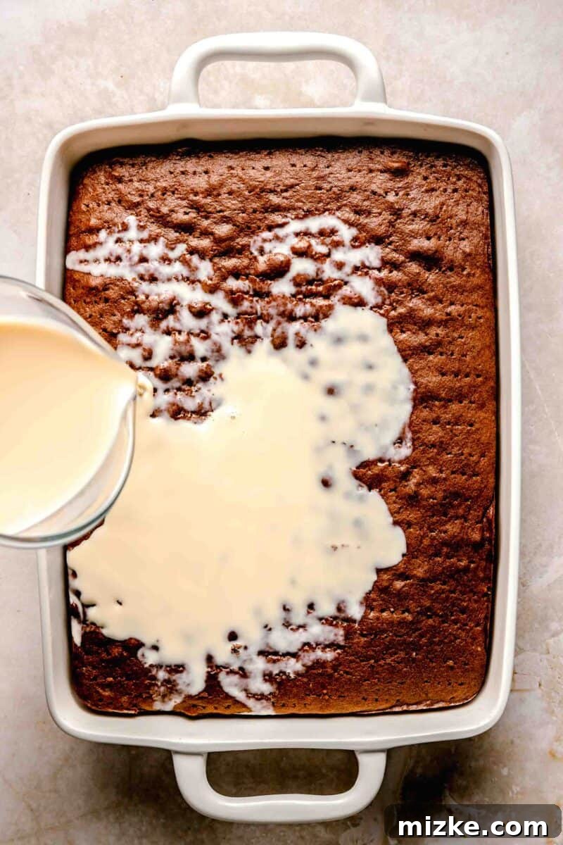 Chocolate cake is soaked in 3 kinds of milk and topped with chocolate Cool Whip and shaved chocolate in this spin on tres leches cake. Slowly pouring the three-milk mixture over the poked chocolate tres leches cake.