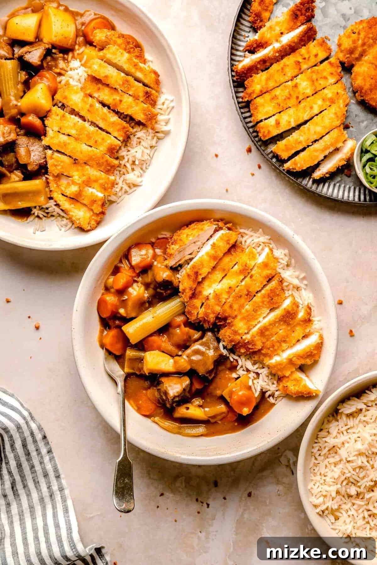 Enjoying a comforting bowl of Chicken Katsu Curry. A beautifully presented bowl of Chicken Katsu Curry, featuring golden, sliced chicken katsu and a rich beef curry over rice, inviting diners to enjoy a hearty and delicious Japanese meal.