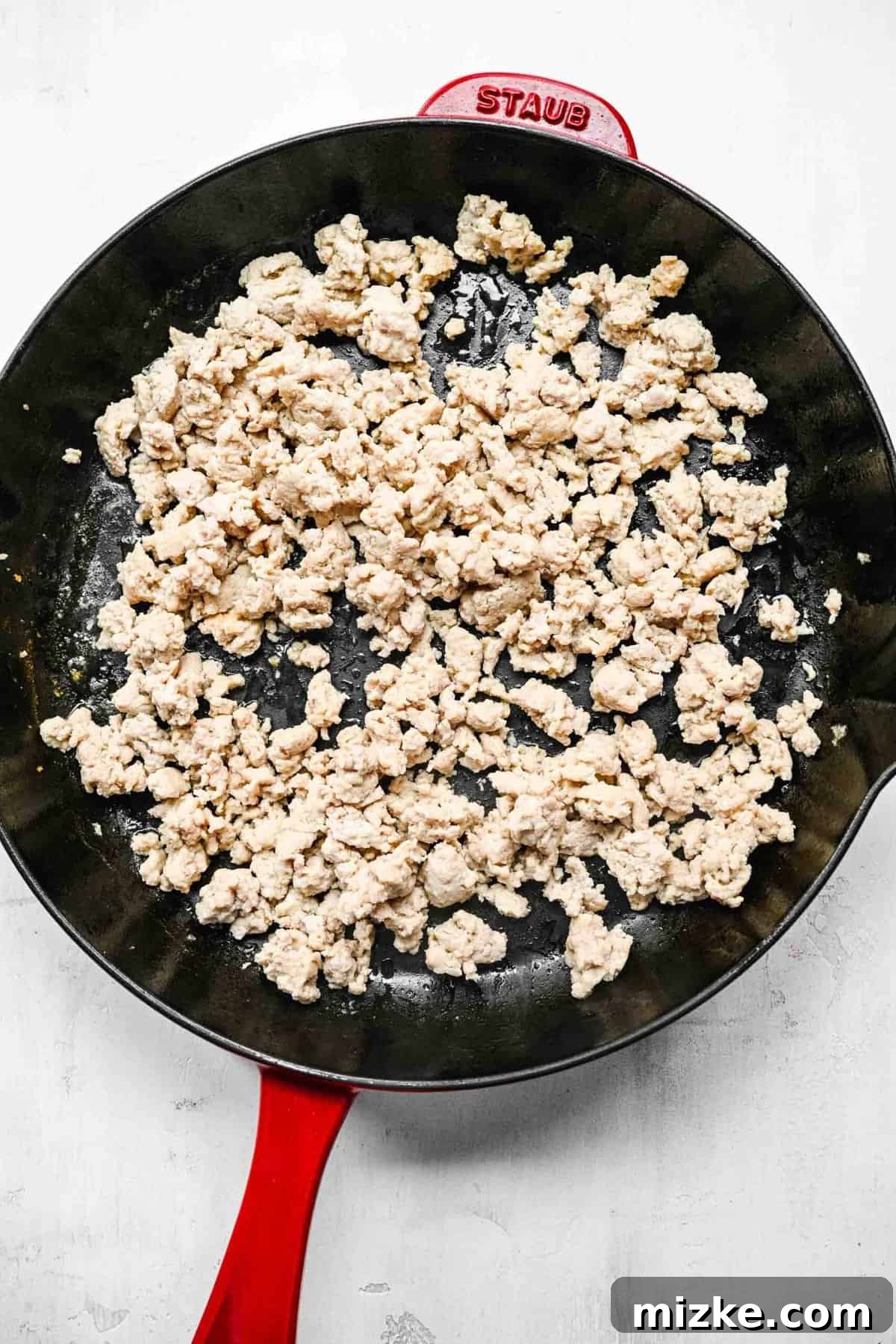 Browning ground chicken for crispy golden spring rolls.