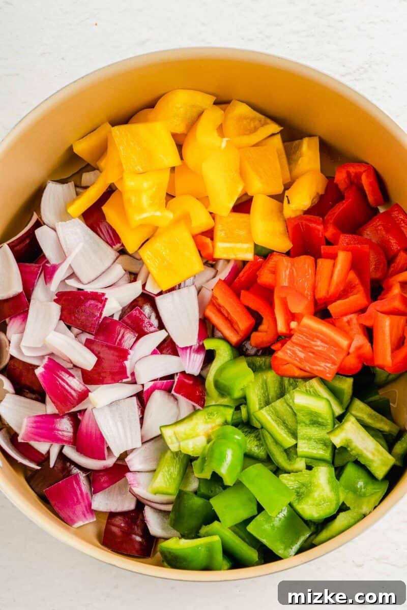 Prepare your vibrant ingredients: freshly diced bell peppers, red onions, and sweet pineapple chunks, perfectly prepped for a delicious and colorful stir-fry. A colorful array of uncooked bell peppers, onions, and pineapple waiting to be sautéed in a large pan, meticulously prepped for the stir-fry.