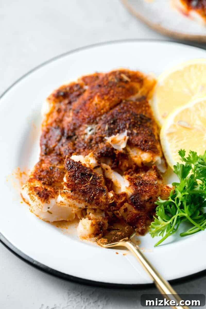 Cajun Spiced Cod Fillet 7 blackened cod flakes on a gold fork
