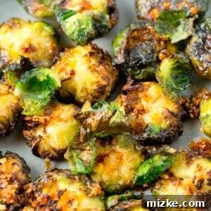 Garlic chili crisp oil on top of crispy smashed Brussels sprouts, served on a plate