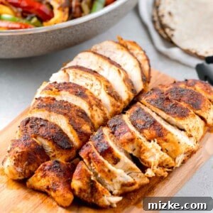 Sliced air fryer blackened chicken on a wooden cutting board, ready to be served or used in other dishes.