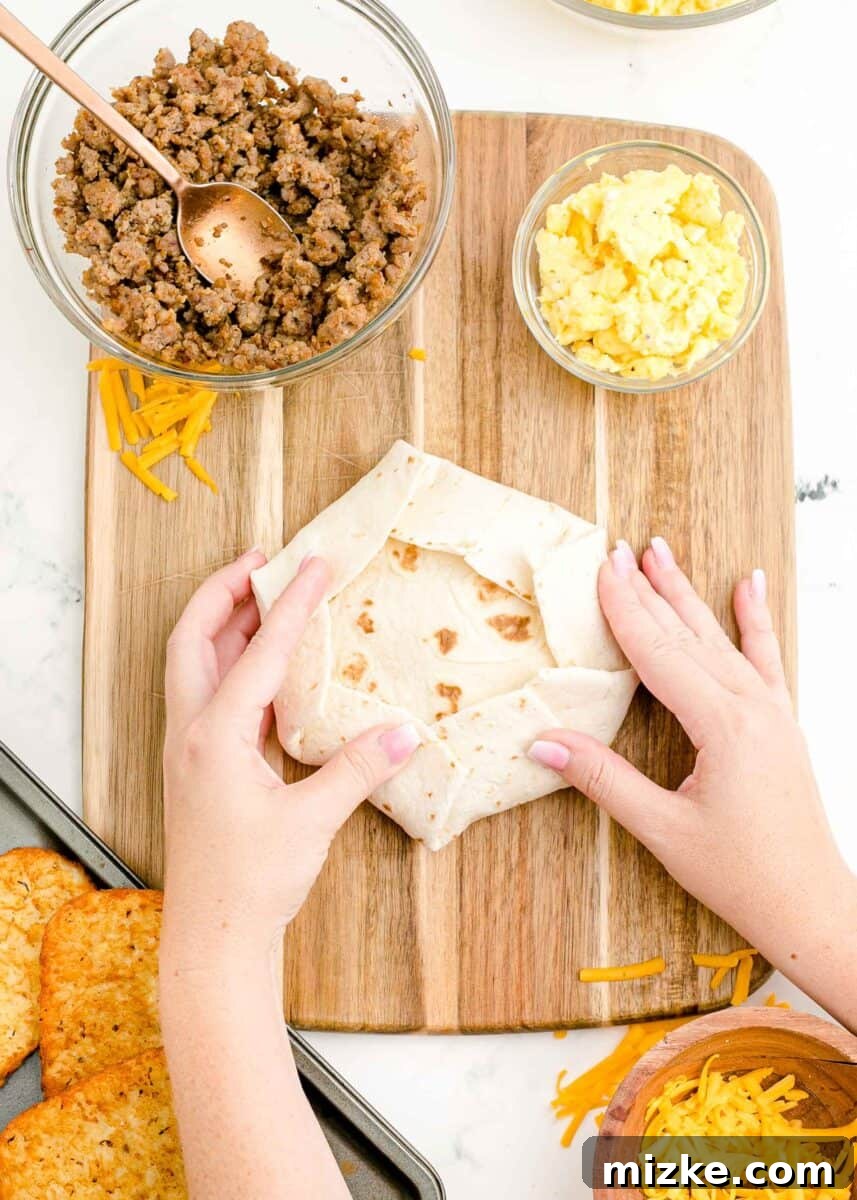 Sunrise Crunch Fold 11 The edges of a large tortilla are meticulously folded inwards, securing all the delicious fillings and the smaller top tortilla into a neat, compact breakfast crunchwrap.