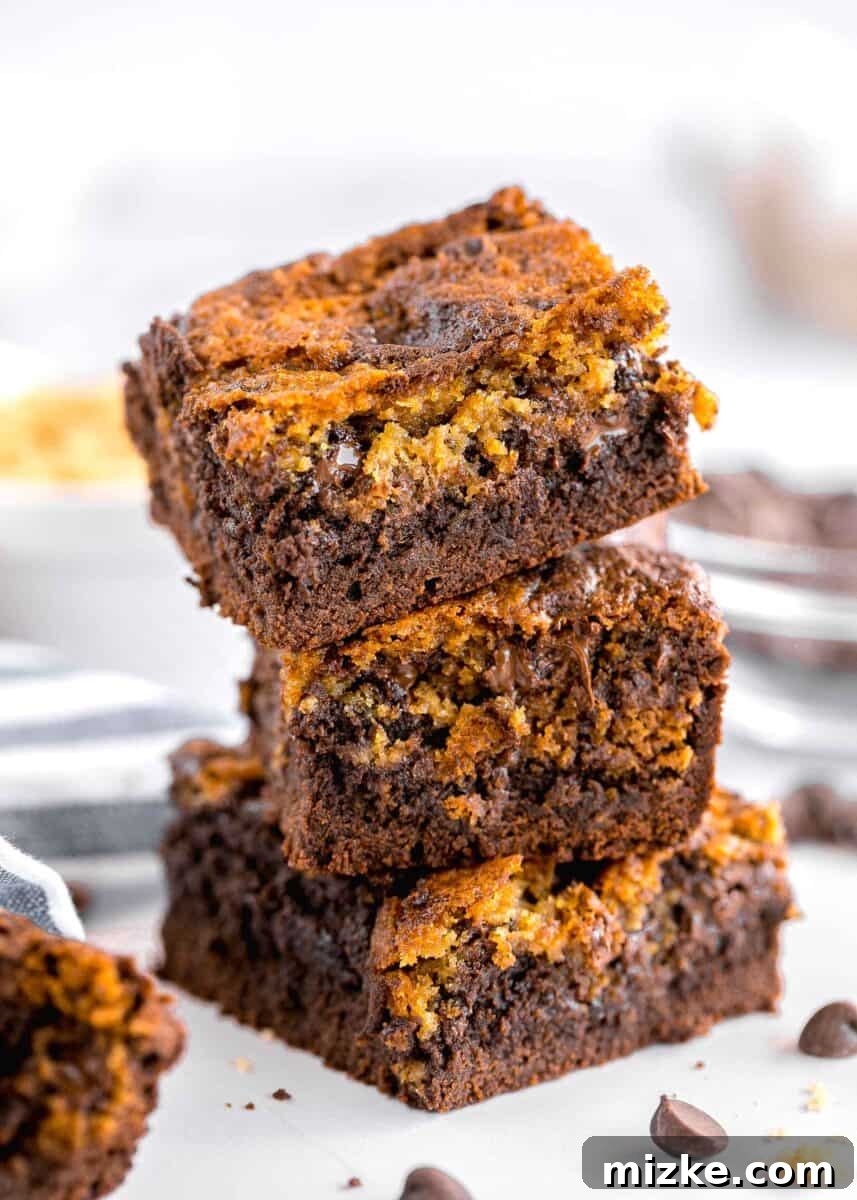 Brownie Cookie Fusion 2 Three decadent homemade brookies are stacked on a pristine white surface, showcasing their perfect blend of fudgy brownie and chewy cookie layers.